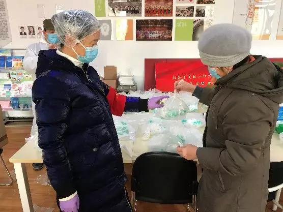 為樓棟分發(fā)口罩，并為包裝袋消毒